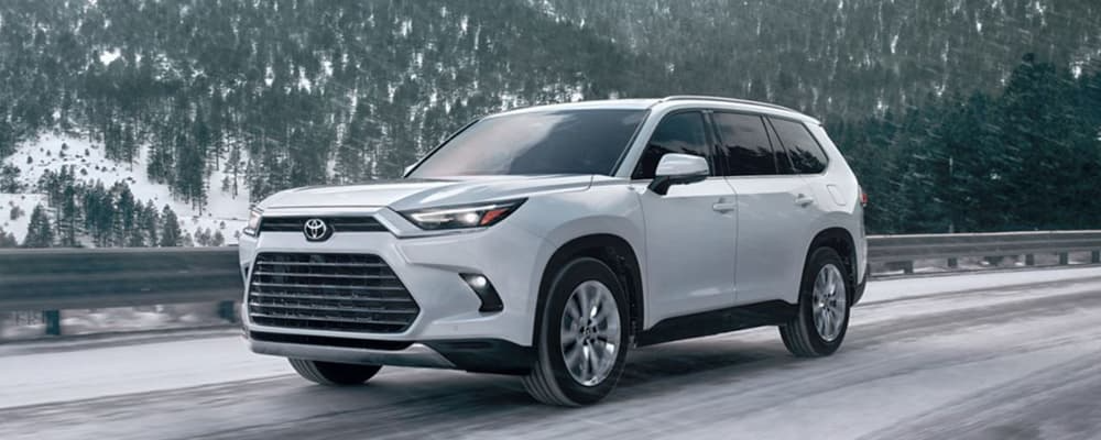 A white Toyota SUV, drives on an icy road.