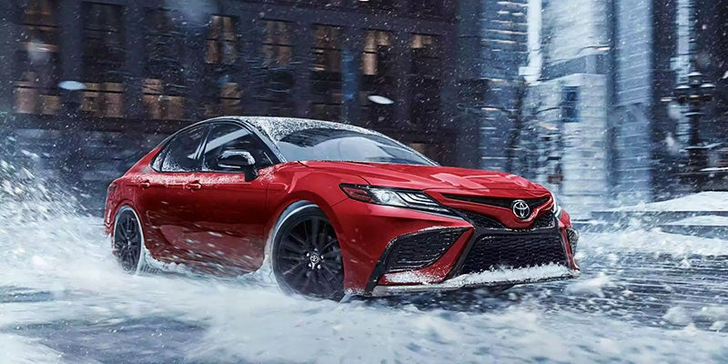 Red camry driving through water