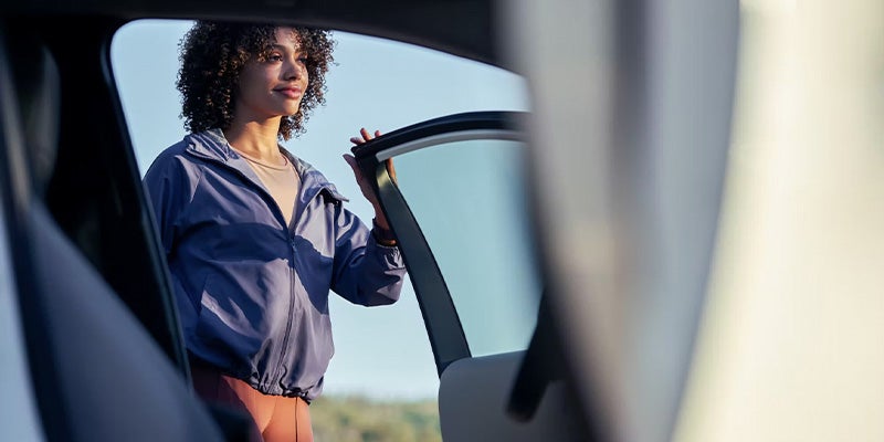Interior view of car and woman standing next to open driver side door