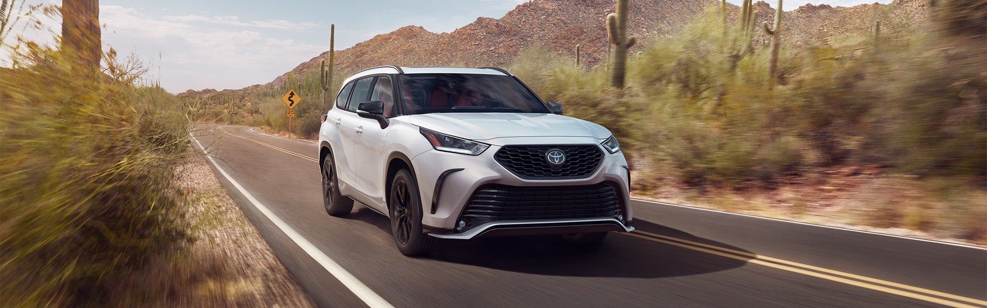 White Highlander driving on highway