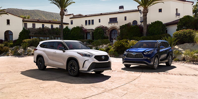 White highlander and blue Highlander vehicles parked