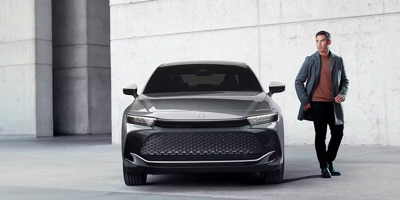 A man walks away from a parked 2024 Toyota Crown