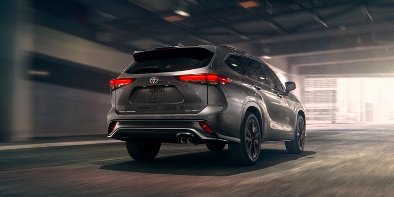 Rear view of a grey 2024 Toyota Highlander driving out of a parking garage