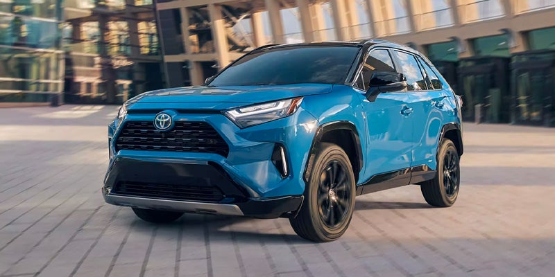 Front right view of a blue 2024 Toyota RAV4 hybrid