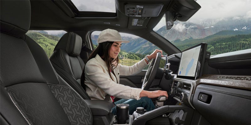 Interior view of a woman sitting in the driver's seat of a Toyota Tacoma